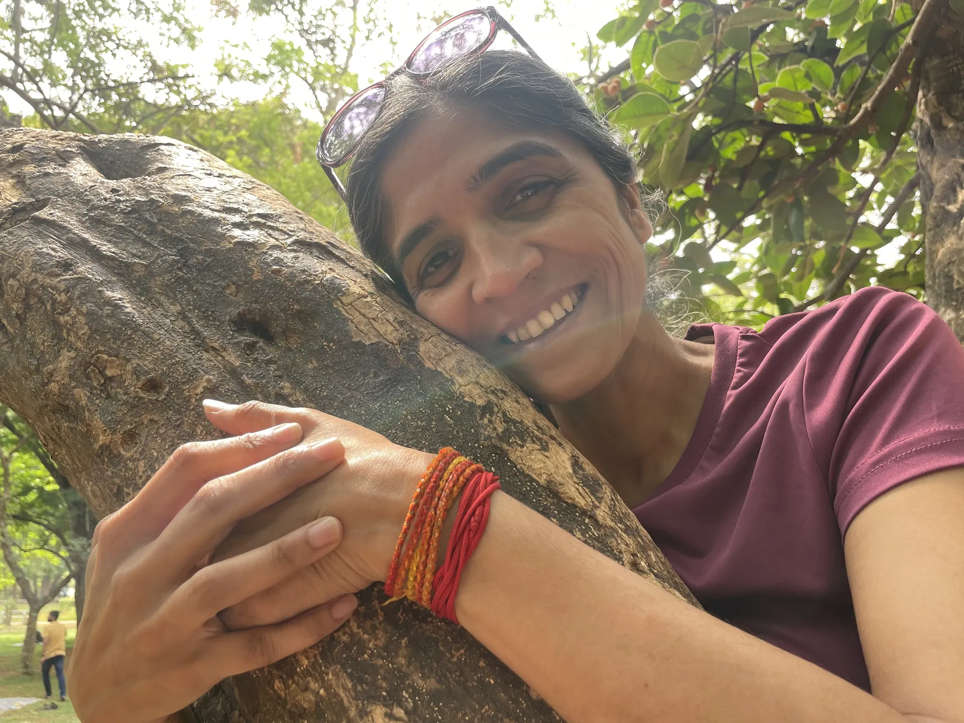 Juanita Rea smiling while embracing a tree in nature